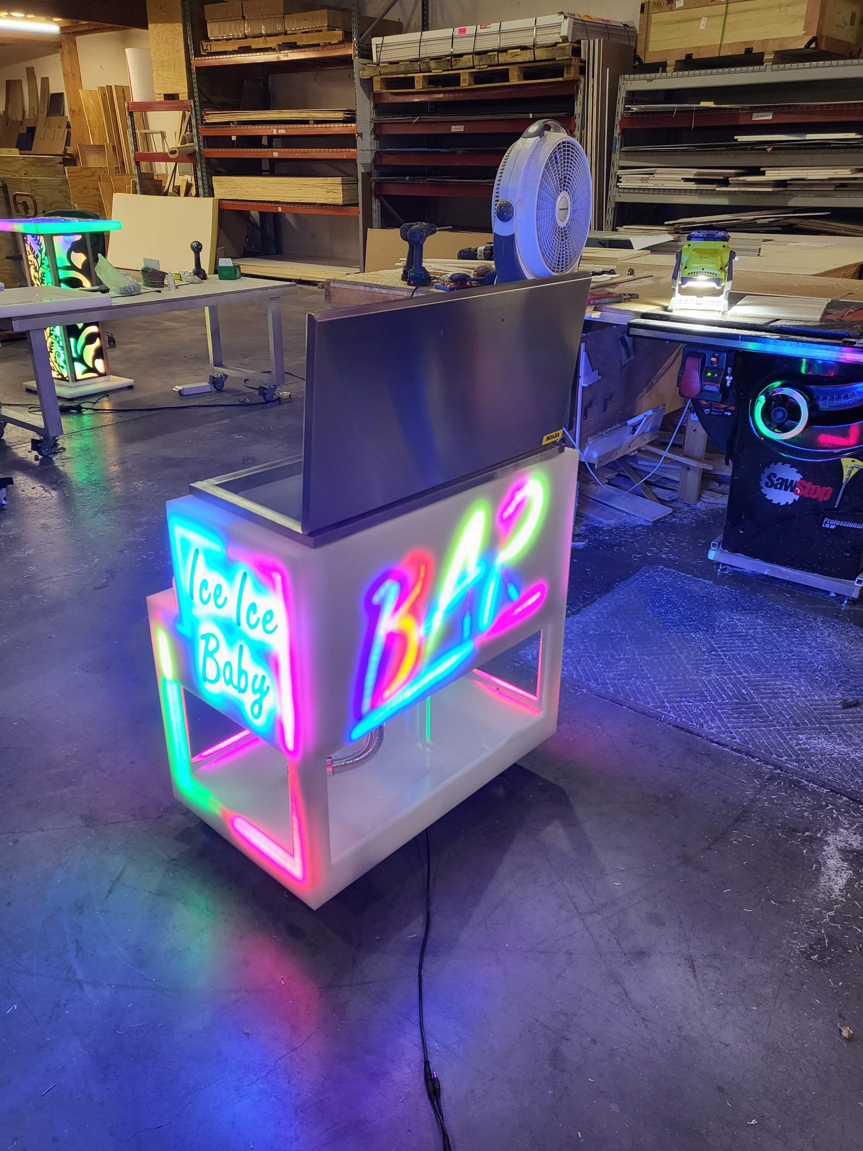 Bar graphics outline in rainbow lighting with open stainless steel cooler lid