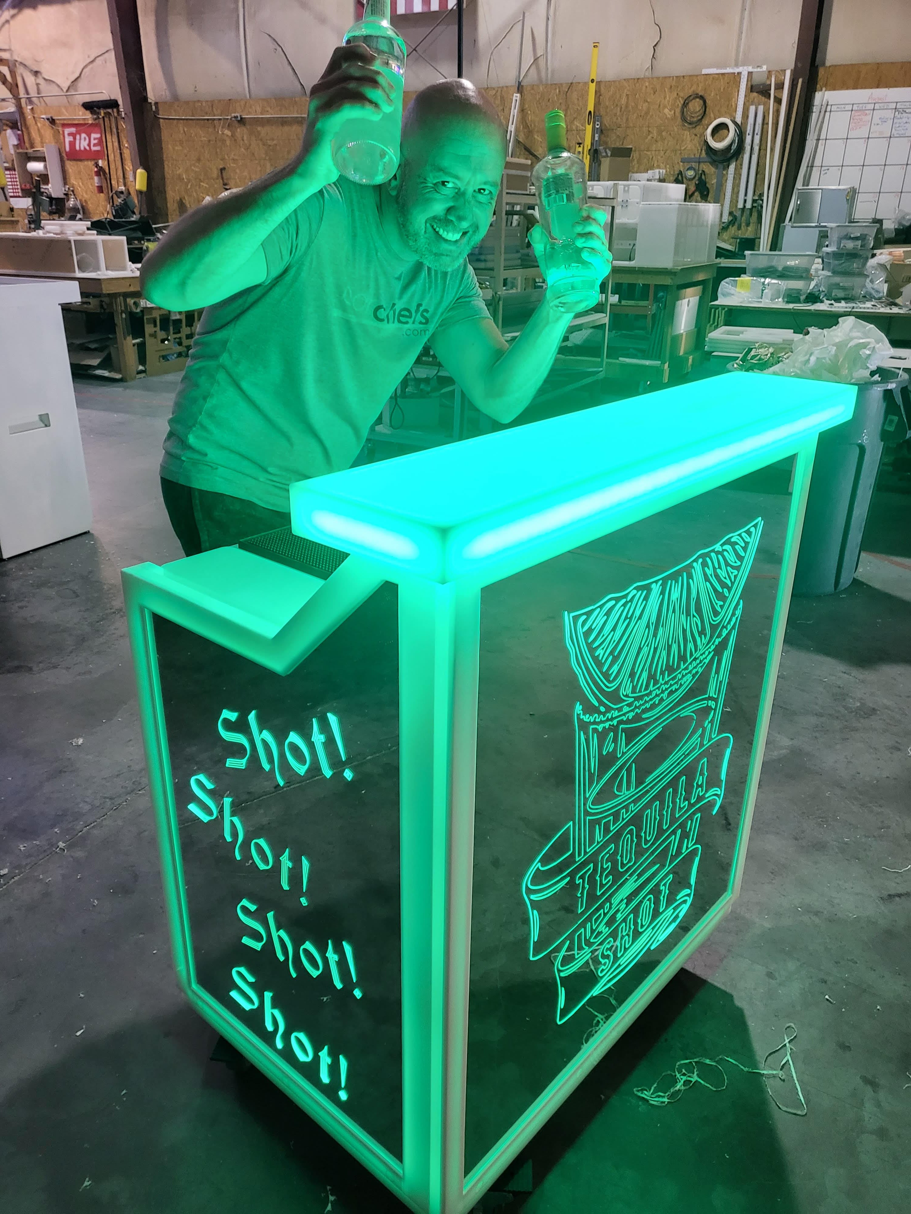 Bartending behind portable bar with tequila shot graphics in green